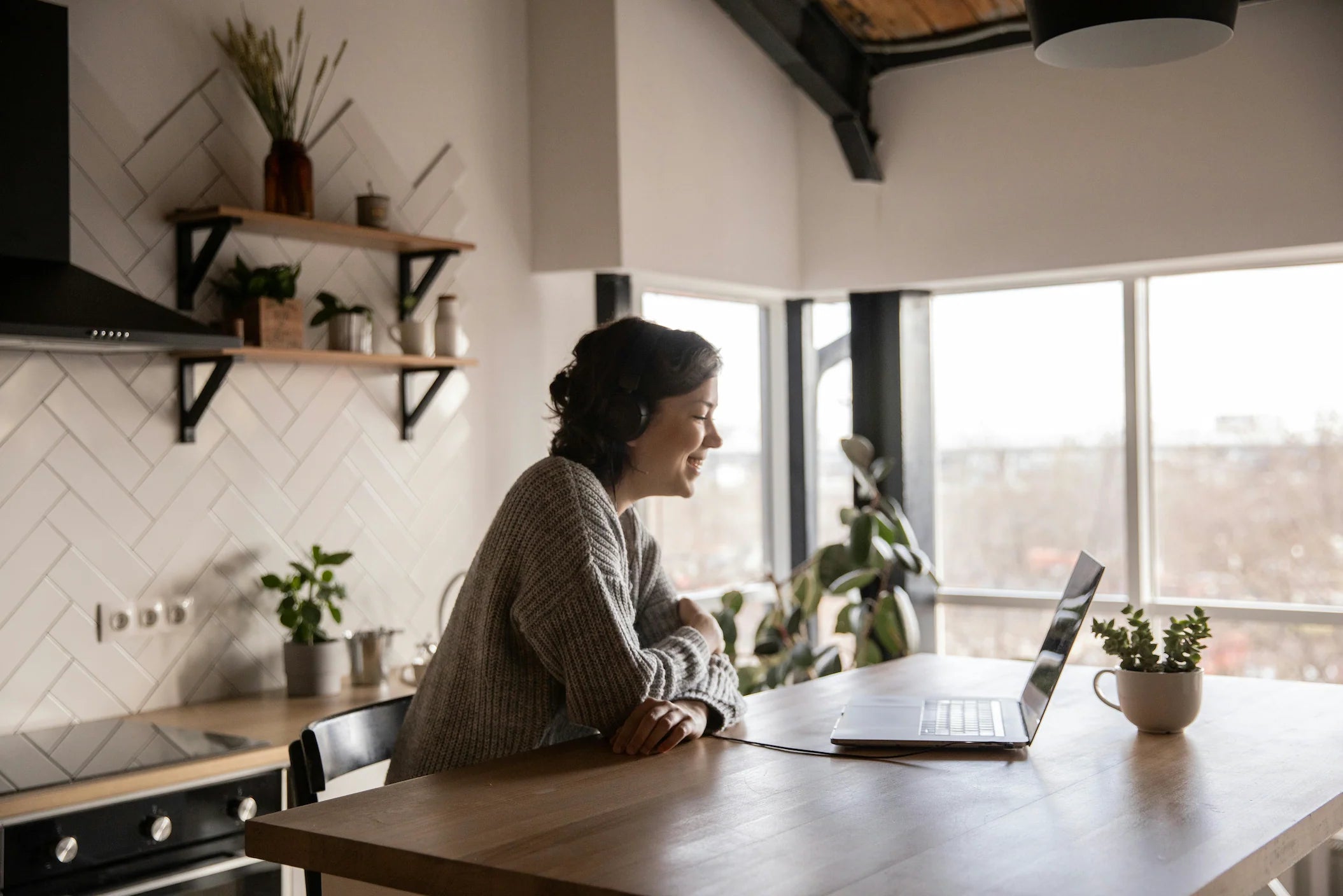 A woman at her kitchen table on a video call